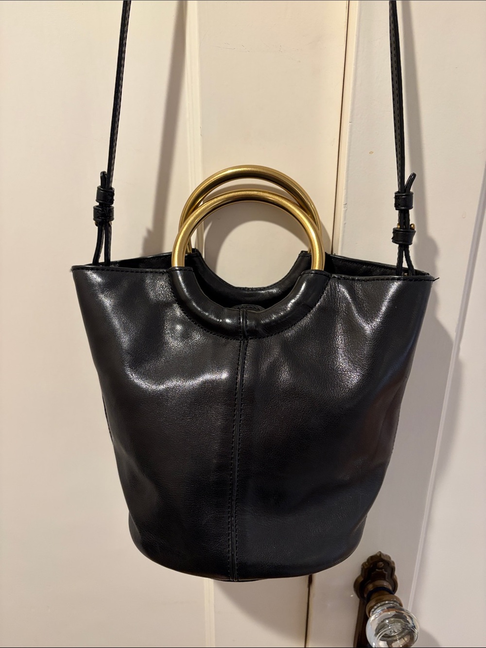 J Crew leather black bucket bag with brass metal handles.